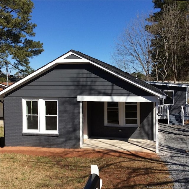 view of front of property featuring a patio and brick siding