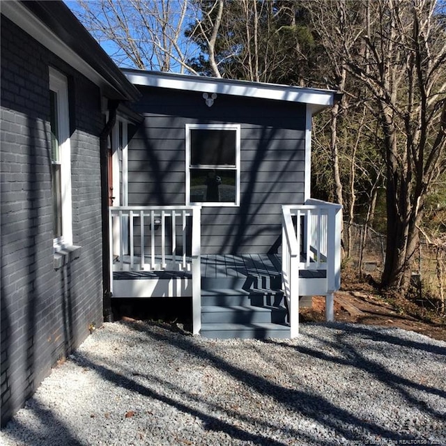 exterior space with brick siding and a wooden deck