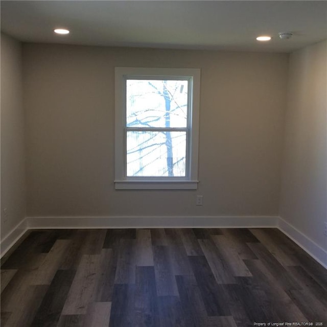 spare room featuring recessed lighting, baseboards, and dark wood-style flooring