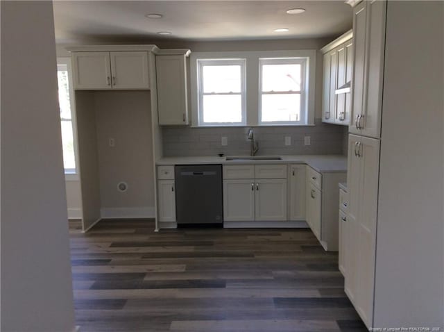 kitchen with dishwashing machine, backsplash, light countertops, and a sink