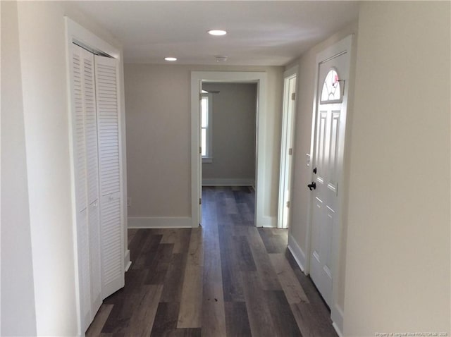 hallway featuring dark wood finished floors, recessed lighting, and baseboards