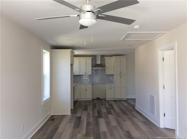 kitchen featuring visible vents, tasteful backsplash, dark wood-style floors, wall chimney exhaust hood, and baseboards