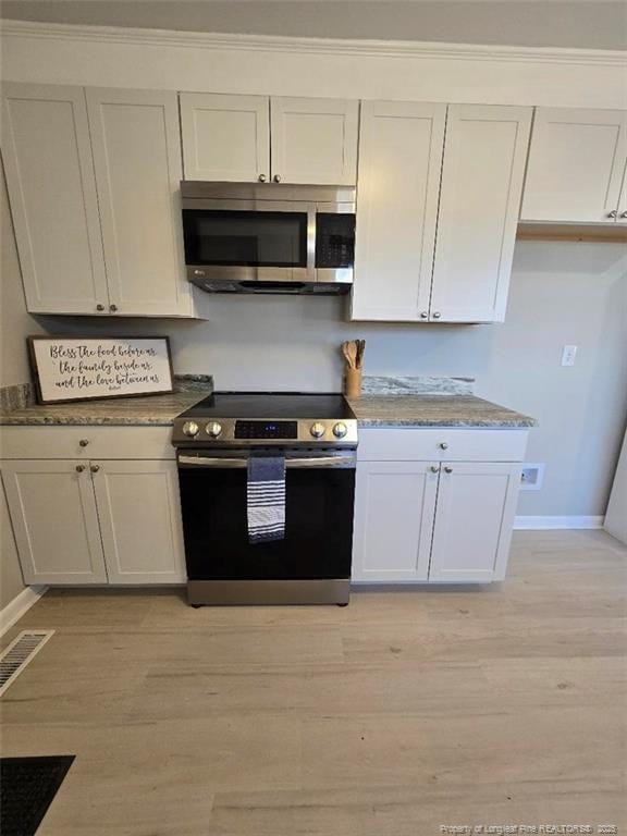 kitchen featuring visible vents, white cabinets, stainless steel appliances, and light wood-style floors