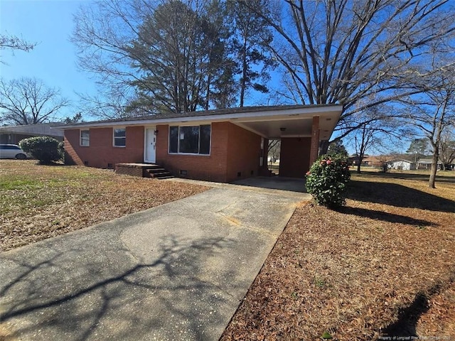 ranch-style house featuring crawl space, concrete driveway, brick siding, and a carport