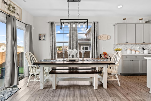 dining area featuring a notable chandelier, light wood-style floors, and recessed lighting