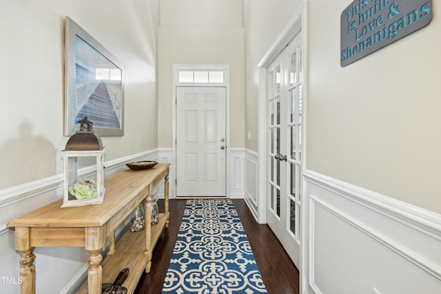 doorway featuring wainscoting, french doors, and dark wood-style flooring