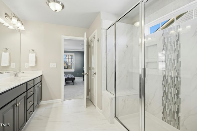 ensuite bathroom with marble finish floor, ensuite bathroom, a marble finish shower, baseboards, and vanity