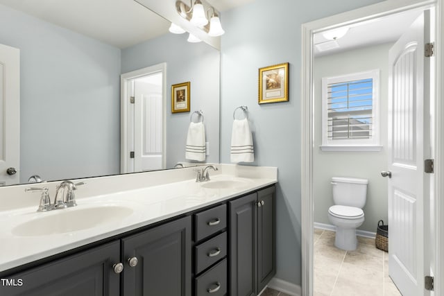 bathroom featuring tile patterned flooring, double vanity, toilet, and a sink