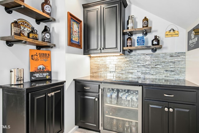 bar featuring a bar, decorative backsplash, wine cooler, and vaulted ceiling