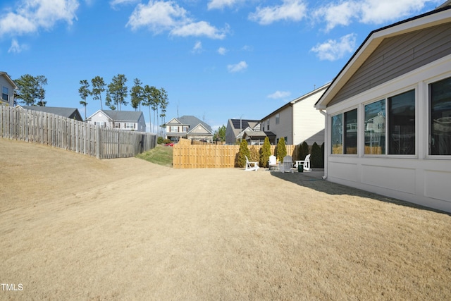 view of yard featuring a residential view, a patio, and fence