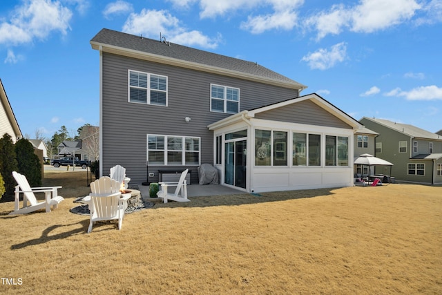 rear view of house with a patio area and a sunroom