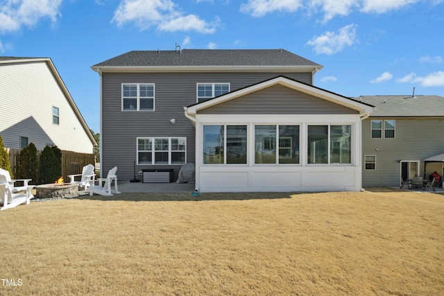 rear view of house featuring a yard, a patio, a fire pit, and fence