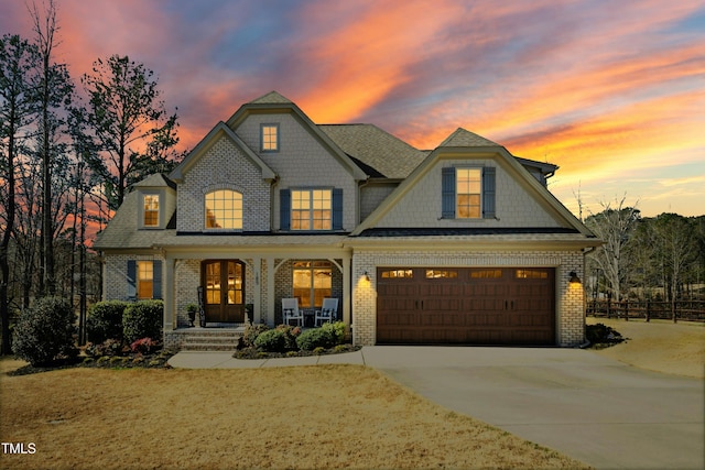 view of front of property featuring brick siding, a porch, concrete driveway, and fence