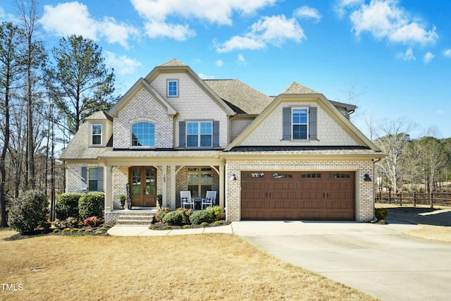 view of front of home featuring brick siding, a shingled roof, a front lawn, covered porch, and driveway