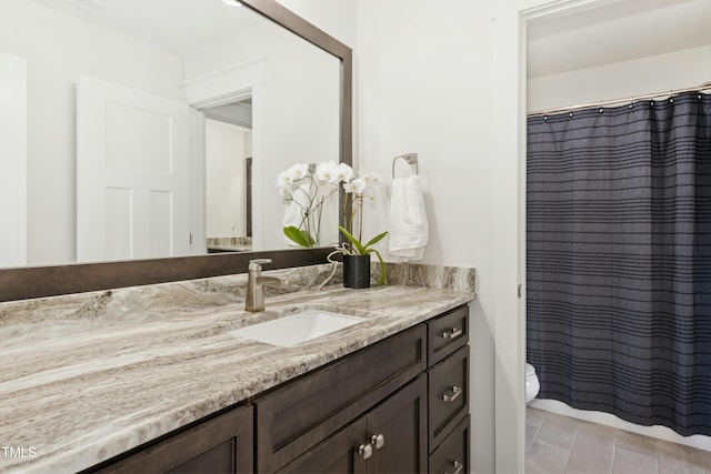 full bathroom with a shower with shower curtain, toilet, vanity, and tile patterned flooring