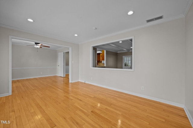 unfurnished room with visible vents, light wood-style flooring, and ornamental molding