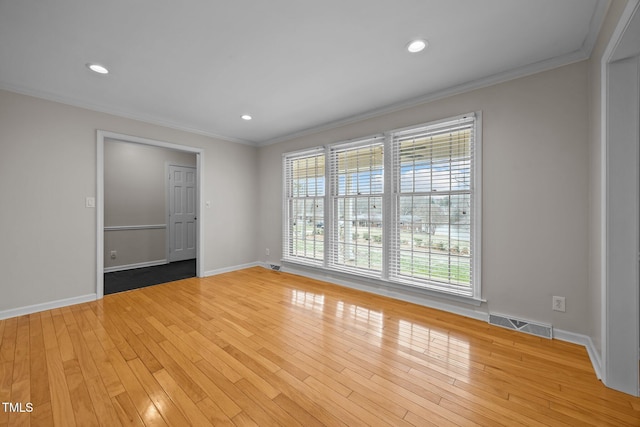 unfurnished room with visible vents, crown molding, and light wood finished floors