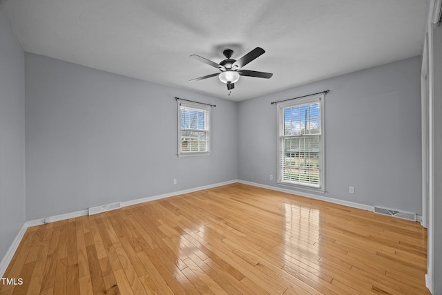 empty room featuring visible vents, baseboards, and light wood-style flooring