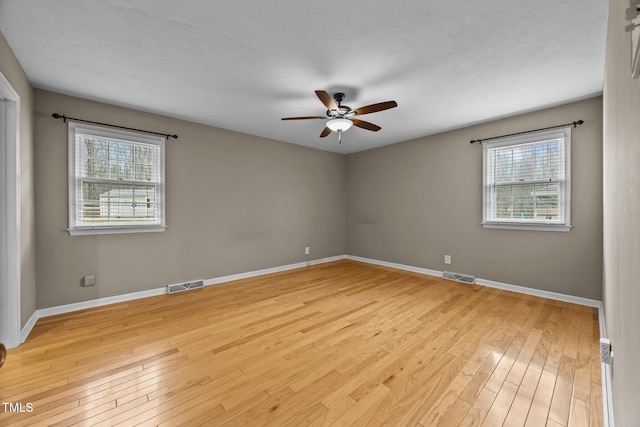 unfurnished room with visible vents, plenty of natural light, and light wood-style flooring