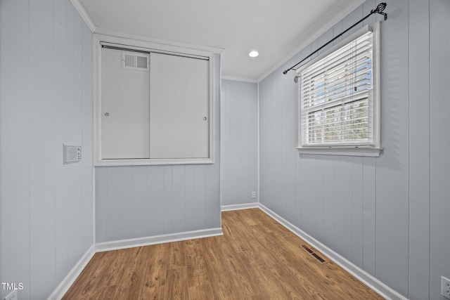 unfurnished room with visible vents, baseboards, and wood finished floors