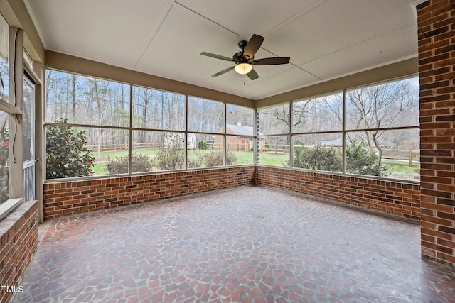 unfurnished sunroom featuring ceiling fan