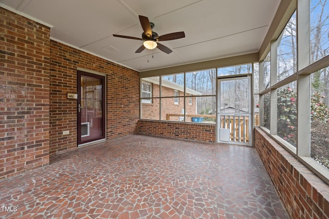 unfurnished sunroom with a ceiling fan and a healthy amount of sunlight