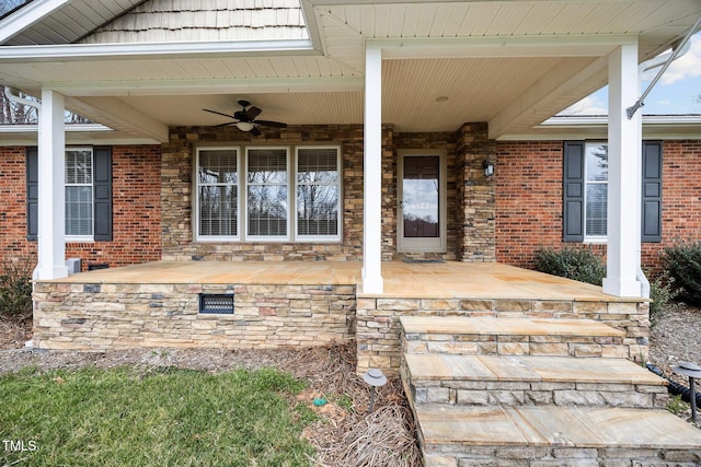 doorway to property with brick siding, covered porch, and ceiling fan