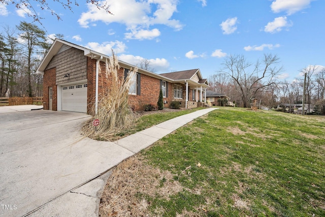 view of side of home with brick siding, a garage, concrete driveway, and a yard