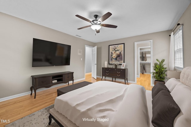 bedroom featuring visible vents, a ceiling fan, baseboards, and wood finished floors