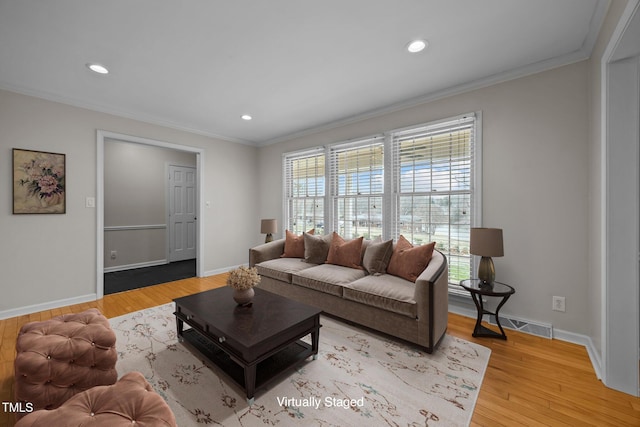 living room featuring baseboards, light wood-style floors, and ornamental molding