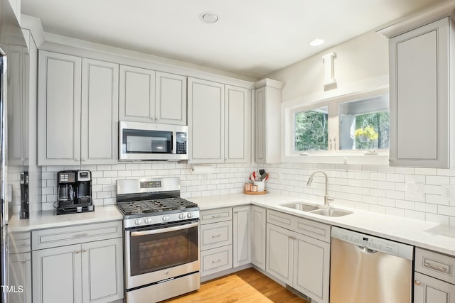 kitchen featuring a sink, decorative backsplash, appliances with stainless steel finishes, and light countertops