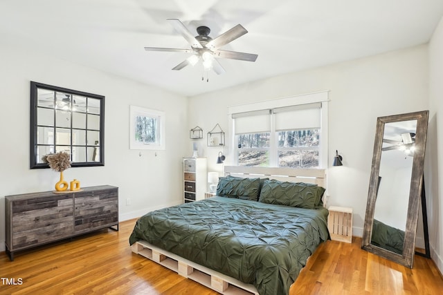 bedroom featuring ceiling fan, baseboards, and wood finished floors