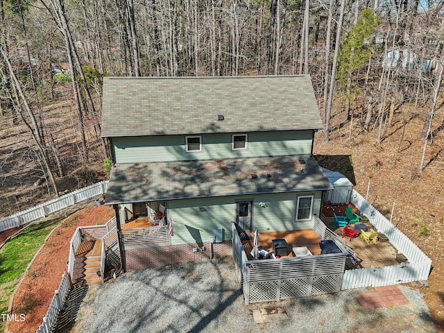 view of front facade with a deck, a tile roof, and fence