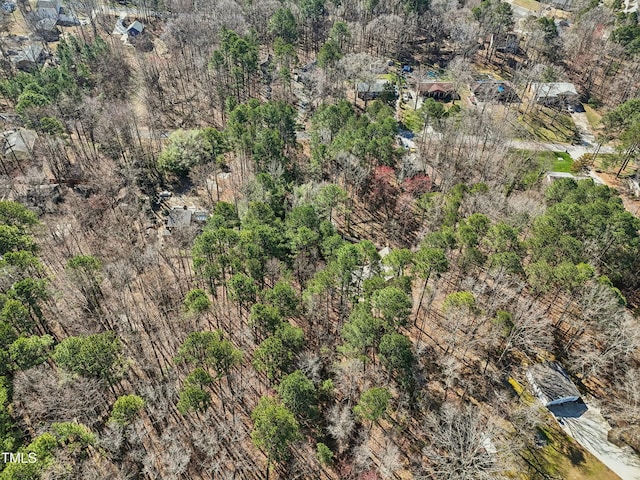 bird's eye view with a wooded view