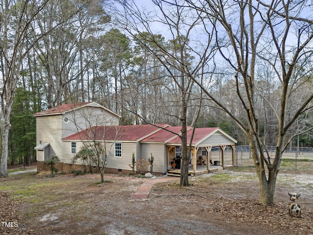 view of front of house with fence and crawl space