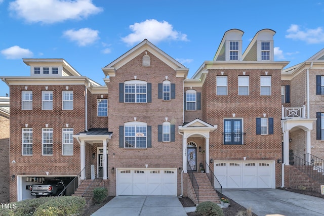 view of front of property featuring brick siding, concrete driveway, and a garage