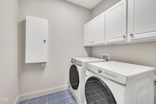 washroom with baseboards, cabinet space, and washer and clothes dryer