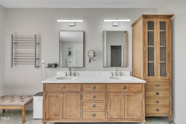 full bath featuring double vanity, radiator heating unit, and a sink