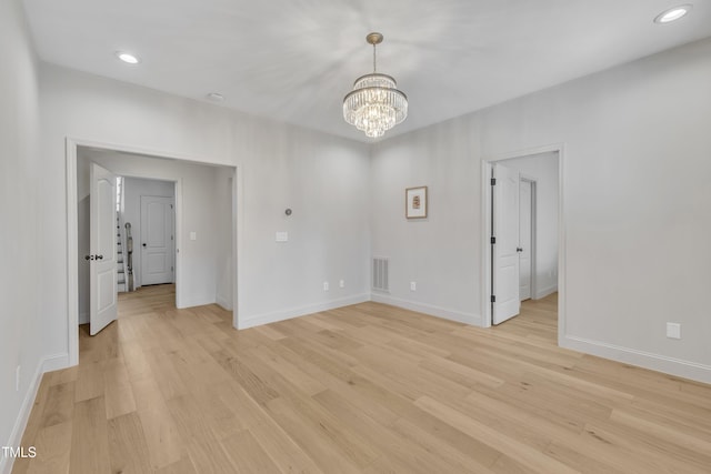 unfurnished room featuring baseboards, visible vents, light wood finished floors, recessed lighting, and a notable chandelier