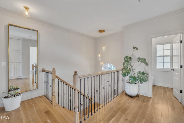 stairway with crown molding, baseboards, and wood finished floors