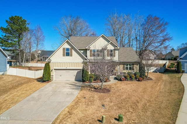 craftsman inspired home featuring board and batten siding, concrete driveway, a front yard, and fence