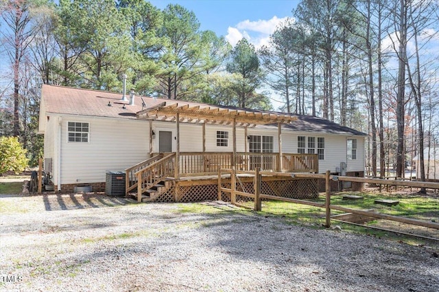 view of front of home with crawl space, a wooden deck, and fence