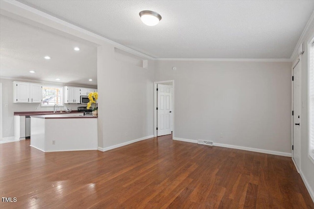 unfurnished living room with dark wood-type flooring, crown molding, visible vents, and baseboards