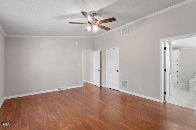 unfurnished bedroom with crown molding, wood finished floors, and visible vents