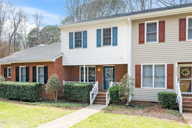 view of front of house featuring a front yard, brick siding, and crawl space