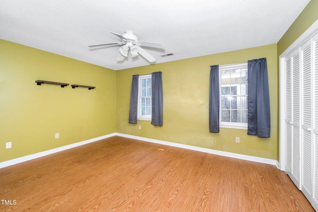 unfurnished room with baseboards, ceiling fan, and wood finished floors