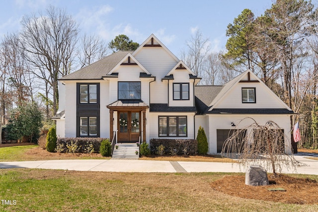 view of front facade featuring a front yard, roof with shingles, concrete driveway, and an attached garage