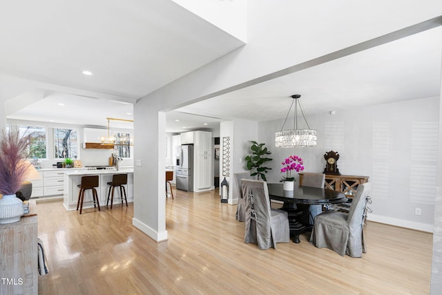 dining space featuring recessed lighting, baseboards, light wood-type flooring, and a chandelier