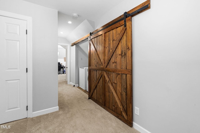 hallway featuring a barn door, recessed lighting, baseboards, and light carpet