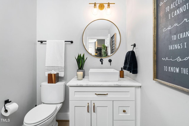 bathroom with toilet, vanity, and baseboards